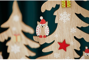Detail of wooden Christmas tree decor with cute owl motif and white snowflake prints