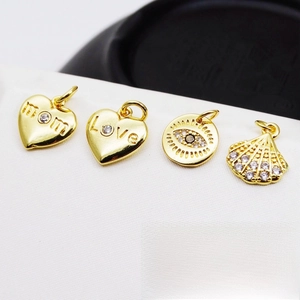 Close-up of gold-plated heart and evil eye charms with micro-pave cubic zirconia