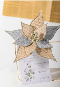 Close-up of artificial linen Christmas flower with leopard print petals and gold glitter