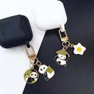 Close-up of enamel panda keychains with bamboo and sun hat charms on golden metal hooks