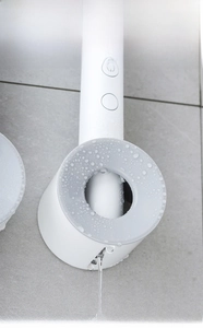 Detail of wall-mounted electric toothbrush holder with large drainage hole and water drops