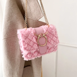 Detail of pink faux fur crossbody bag featuring golden deer buckle and chain on coat