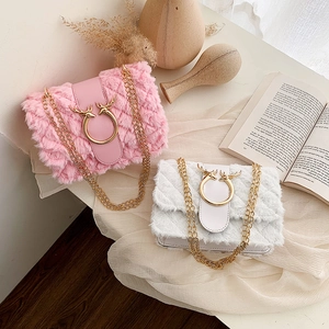 Detail of pink and white plush crossbody bags with gold chains and antler buckles