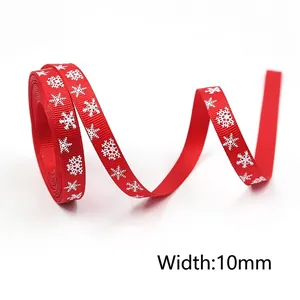 Detail of 10mm red Christmas ribbon featuring white snowflake patterns and ribbed texture