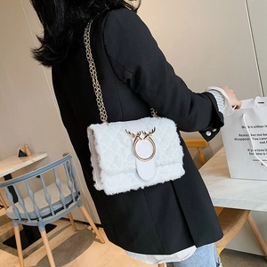 Detail of white plush crossbody bag with gold deer antler buckle and chain strap