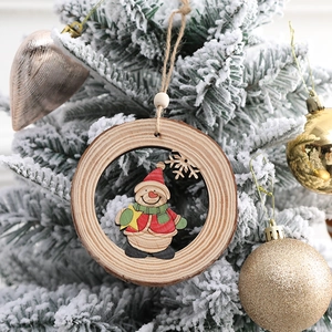 Decorazione natalizia rustica in legno con pupazzo di neve appesa a un albero innevato