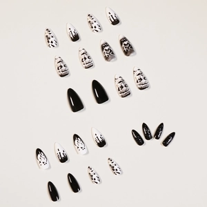 Dark punk almond press-on nails with skull-inspired black and white abstract art design