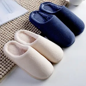 Plush winter slippers in navy and cream white on a textured mat for home warmth