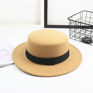 Close-up of a camel wool flat top boater hat with a black grosgrain ribbon detail