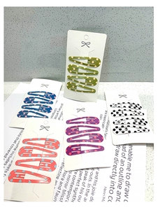 Detailed view of teardrop metal clips set featuring vibrant polka dot patterns on cards