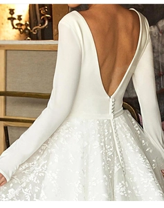 Détails de la robe de mariée à manches longues avec boutons au dos et broderie de dentelle