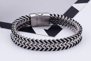 Detail of men's stainless steel bracelet with silver and black braided design and magnetic clasp