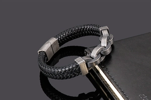 Détail d'un bracelet en cuir tressé avec chaîne en acier inoxydable sur un carnet