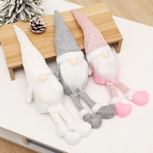 Three sequined Nordic Christmas gnomes in pink, white and grey on a festive winter table