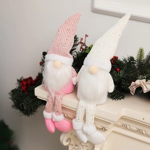 Pink and white Nordic Christmas gnomes with sequin hats on a cozy fireplace mantel
