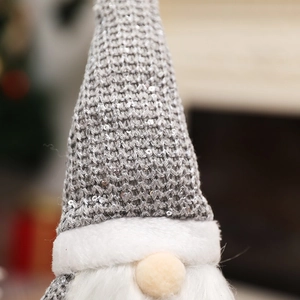 Detail of grey knitted gnome hat with silver sequins and white faux fur beard