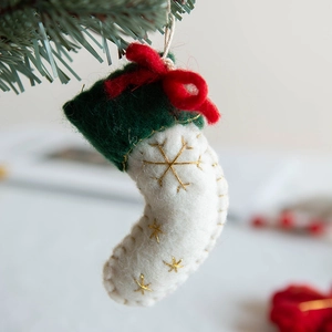 Handmade wool felt Christmas tree ornament in white and green with a red bow tie