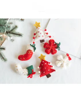 Handmade wool felt Christmas ornaments set with trees and socks on soft background