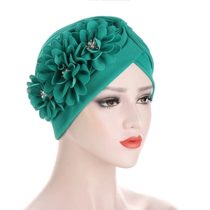 Turbant vert plissé avec fleurs en tissu 3D et perles décoratives sur mannequin