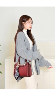 Detail of burgundy leather tote bag featuring white embroidery and leopard silk scarf