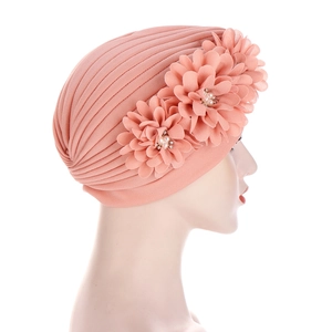 Turban plissé rose pour femme orné de trois fleurs en tissu et détails en perles