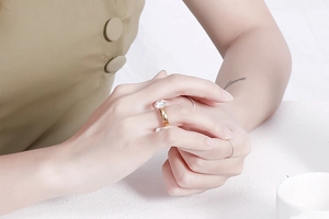Detail eines 4mm goldfarbenen Edelstahlrings mit rundem Zirkon auf einer Frauenhand