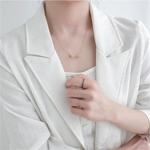 Detail of minimalist 925 sterling silver gold interlocking ring necklace and matching rings