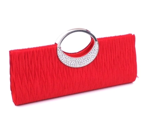 Close-up of red pleated evening bag with silver rhinestone handle detail and texture