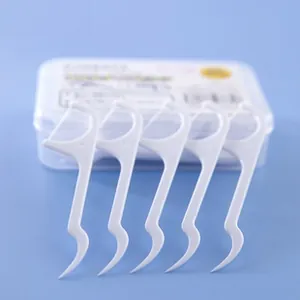 Detail view of 5 dental floss picks with toothpick ends on a blue background