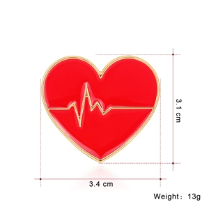 Vue détaillée de la broche en forme de cœur avec émail rouge, bordures dorées et motif ECG