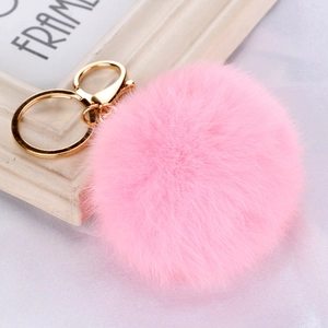 Detailed view of pink faux fur pompom keychain with polished golden metal lobster clasp