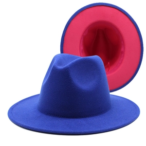 Detail view of two-tone wool fedora hat with navy exterior and bright pink interior lining