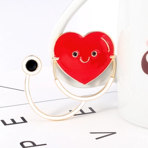 Broche stéthoscope cœur rouge émaillé avec visage souriant sur une tasse en porcelaine