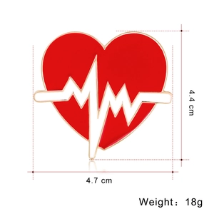 Détail de la broche cœur rouge avec ligne ECG, montrant les dimensions 4,7cm x 4,4cm et poids