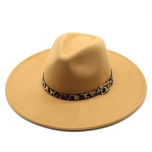 Detail of tan fedora wool hat showing leopard print band and gold buckle on a wide brim