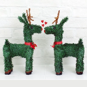 Pair of 40cm green tinsel Christmas reindeer ornaments with red bows on white background