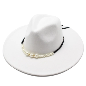 Detail of white wool fedora with black ribbon featuring pearls and gold accents