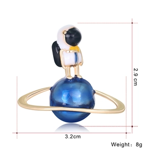 Detailed size view of an astronaut standing on a blue planet enamel brooch pin