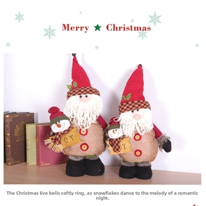 Detail of Christmas gnomes with long white beards holding JOY signs on wooden desk