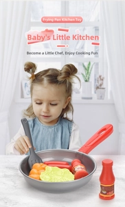 Detailed play kitchen set with grey frying pan, spatula, and assorted toy vegetables