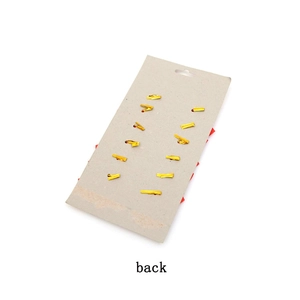 Close-up of 10 gold metal fasteners on cardboard back for Christmas bows decoration