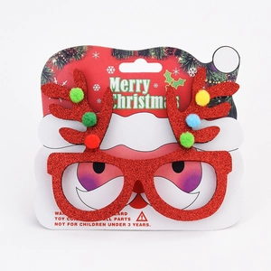Detail of glittery red reindeer antler Christmas glasses with colorful pom-poms on card
