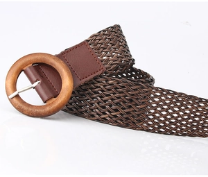 Macro detail of dark brown woven belt texture and natural grain of round wooden buckle