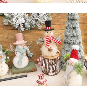 Detailed view of various Christmas snowman figurines with knitted hats on wooden background