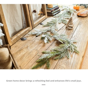 Detail of snowy artificial pine garland on a wooden table for Christmas decor