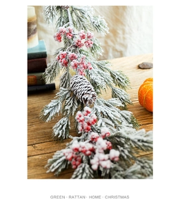 Close-up of Christmas rattan with snowy pine needles, red berries, and natural pinecones