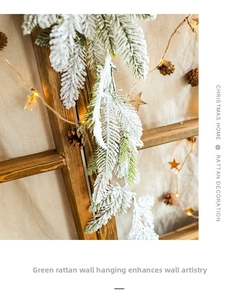 Detail of snowy flocked Christmas garland with warm LED lights and natural pine cones