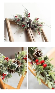 Detailed view of Christmas pine cones and red berries with snow effect on green branches