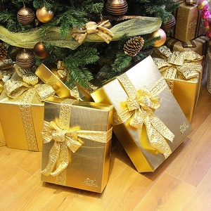 Scatole regalo di Natale dorate con lamina metallica e nastri sotto l'albero
