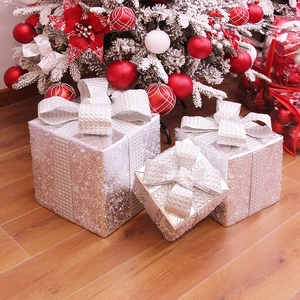Set di 3 scatole regalo di Natale in argento scintillante sotto un albero addobbato